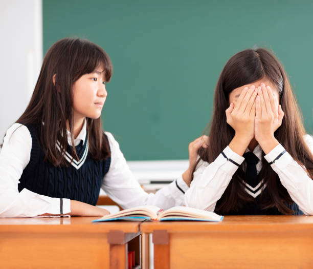 istock Friend comforting to sad student in classroom 990711790
