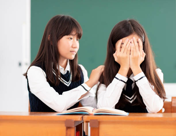 istock Friend comforting to sad student in classroom 990711792