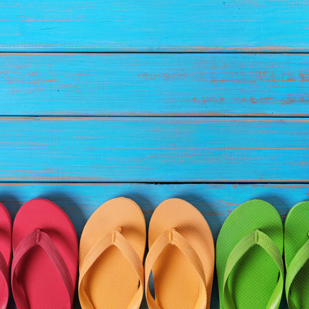 istock Flip flops in a row blue beach wood background 990714926
