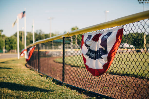 amerikanische flagge auf einem metallzaun - horizontal gestreiften vorhängen stock-fotos und bilder
