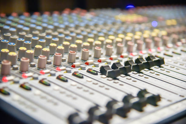 istock close-up hands of sound engineer adjusting audio mixer controller for live music and studio equipment. This is a quality audio system for professionals. vintage tone & effect light in control room. 990722850