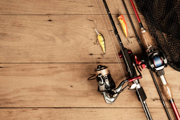 istock Fishing tackle on wood background on top view 990755372