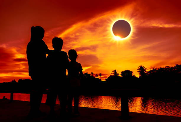 Natural phenomenon. Three looking at looking at total solar eclipse. Amazing scientific natural phenomenon. The Moon covering the Sun. Silhouette of mother and children looking at total solar eclipse with diamond ring effect on sky. Happy family spending time together. eclipse photos stock pictures, royalty-free photos & images