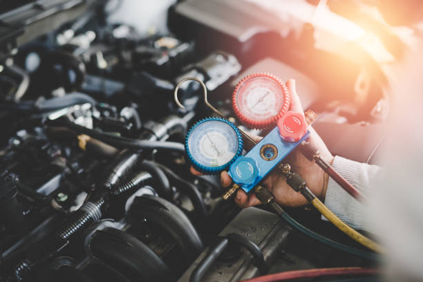 Hand of young mechanic with Gauges Set, Check the pressure and leak. Servicing car air conditioner Hand of young mechanic with Gauges Set, Check the pressure and leak. Servicing car air conditioner compressor photos stock pictures, royalty-free photos & images