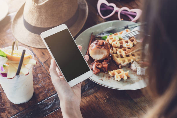 istock Young woman using smart phone and enjoy eating dessert in cafe 990794808
