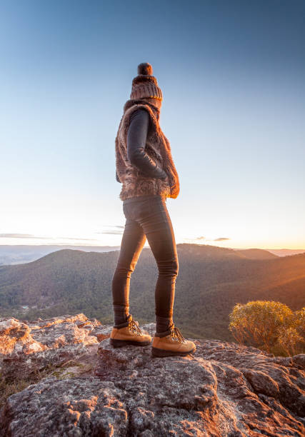 istock Woman looking at mountain views at edge of cliff 990805280