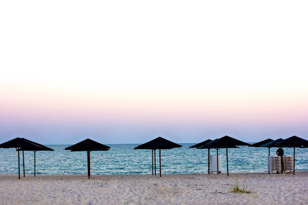istock Empty beach, beach umbrellas and beautiful sunset. Romantic atmosphere. 990806040
