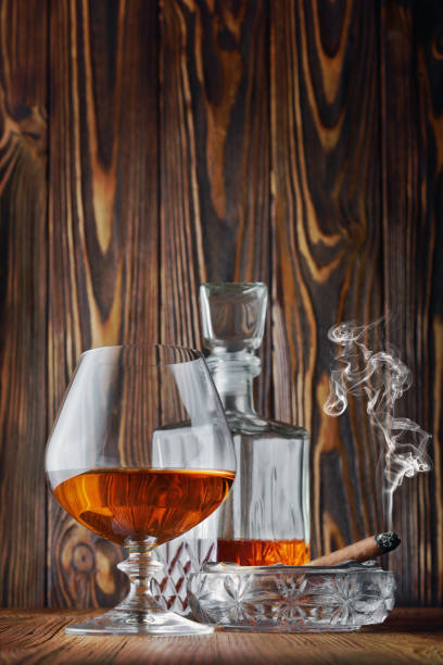 istock Strong alcoholic drink cognac in sniffer glass and decanter with smoking cigar 990819006