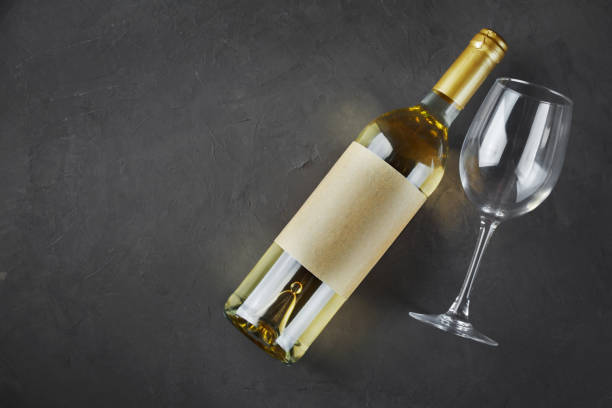 istock Flat lay of lying white wine bottle with empty label and glass for tasting 990819126