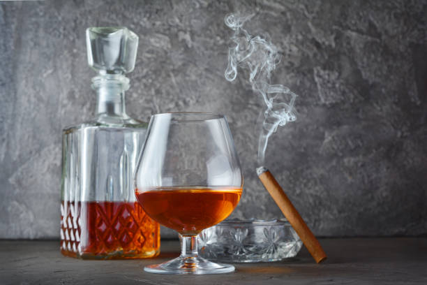 istock Strong alcoholic drink cognac in sniffer glass and decanter with smoking cigar 990821696