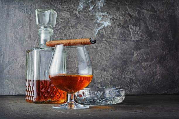 istock Strong alcoholic drink cognac in sniffer glass and decanter with smoking cigar 990821780