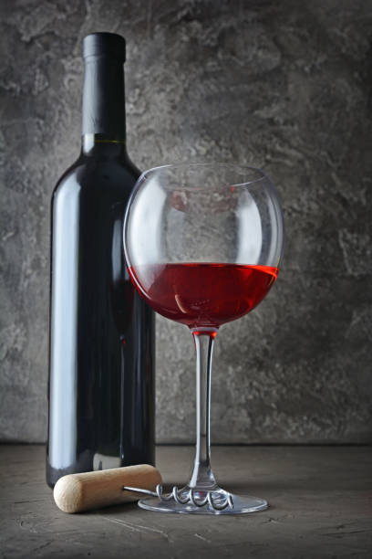 istock Red wine bottle and glass for tasting with corkscrew 990821916