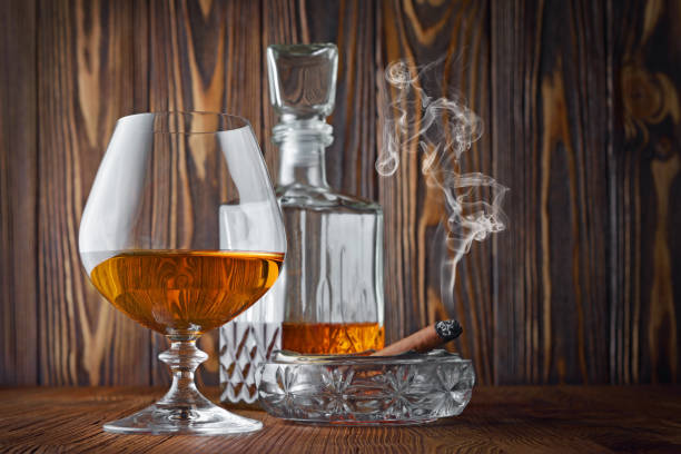 istock Strong alcoholic drink cognac in sniffer glass and decanter with smoking cigar 990822072