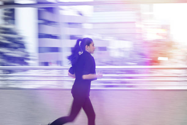 istock Abstract blurred motion of young Asian business woma running to work with light effect. 990827100