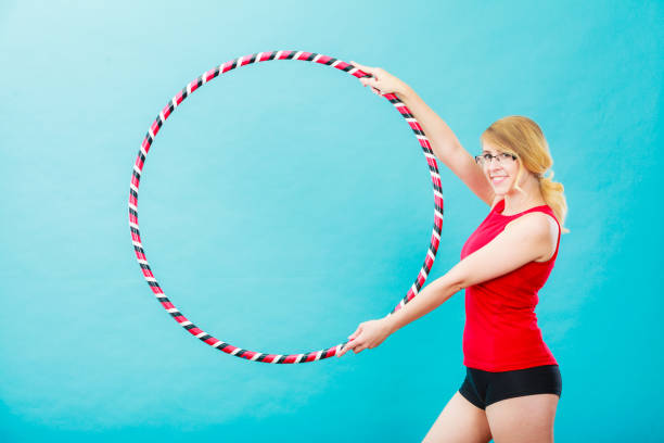 istock Fit woman with hula hoop doing exercise 990829734