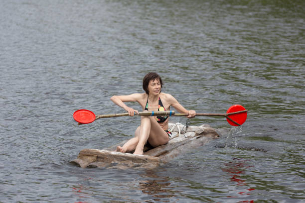 istock woman with a paddle on a wooden raft 990853308