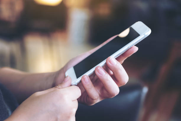 istock Closeup image of a woman's hands holding and using smart phone in cafe 990856460