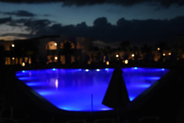 istock Reflections of lights on a pool at night 990857496