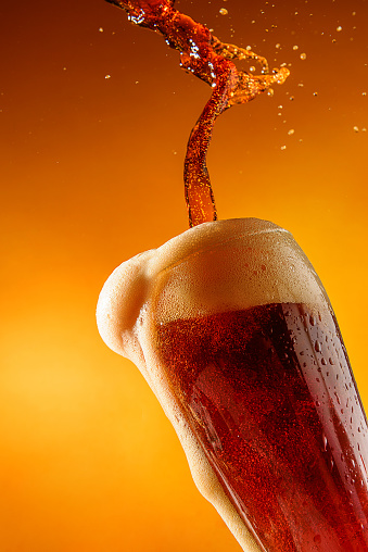 Cold fresh beer is poured into a glass