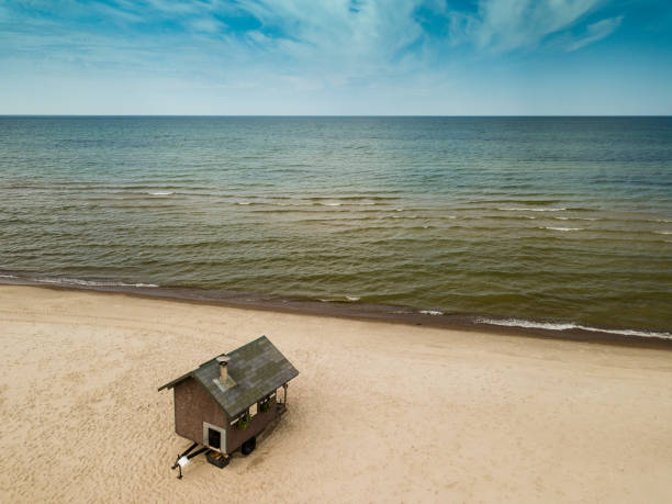 istock Small sauna house on the seashore. Bathhouse. Sandy beach. 990864158