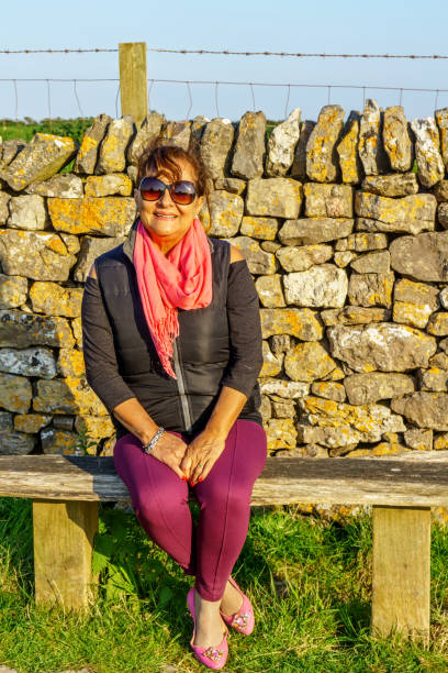 istock Senior Hispanic woman sitting on bench 990864890