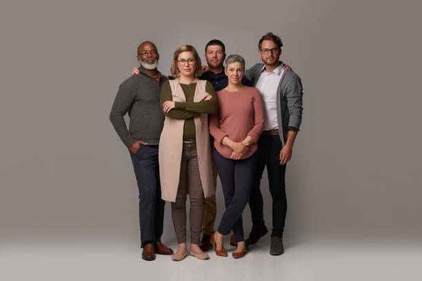 United we stand Studio shot of a group of people posing together against a gray background organised group photo stock pictures, royalty-free photos & images