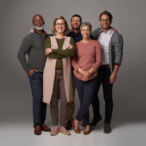 We're so much better when we stand together Studio shot of a group of people posing together against a gray background mixed age range stock pictures, royalty-free photos & images