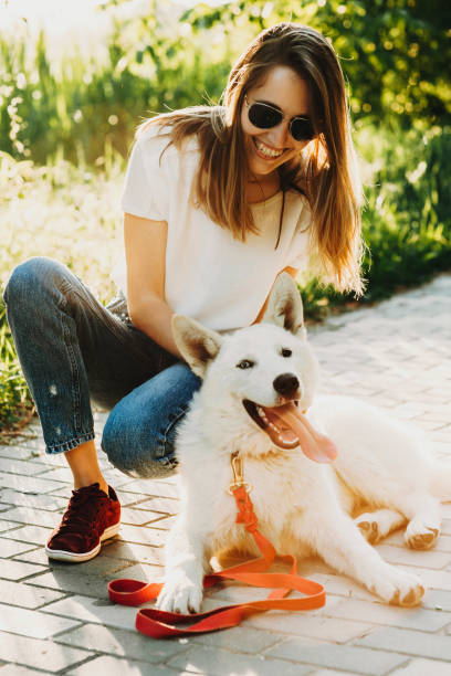 istock Happy female and dog sitting on pavement 990876524