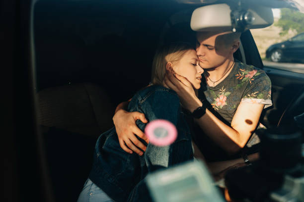 istock Couple hugging sitting in car 990876702