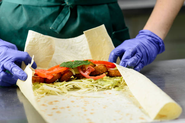 istock Process of preparing appetizing roll with falafel, vegetables an 990877680