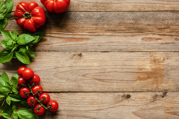 istock Tomatoes and basil on wood background, cooking ingredients 990894058