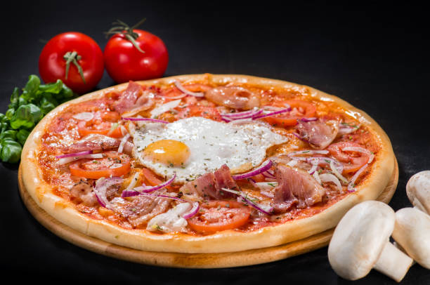 istock Pizza Palermo with mozzarella, bacon, onion, tomatoes and egg on 990899812