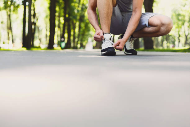 istock Unrecognizable man tying shoelaces before running 990922504