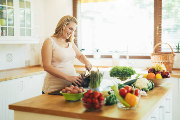 istock Pregnant woman making a meal in kitchen 990926202