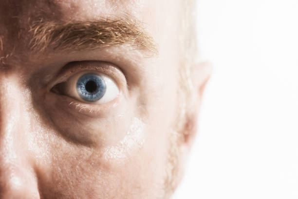 istock Mature man's blue eye in cropped close-up looking shocked 990940942