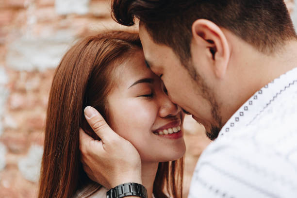 istock Lovely asian couple by a brick wall 990950128