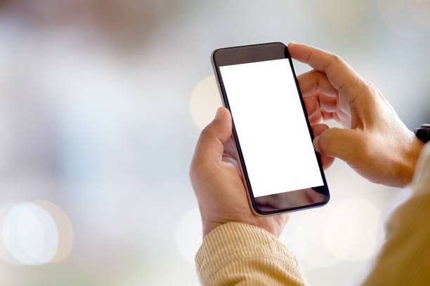 Closeup male hands using smartphone at blurred business centre background. Blank screen mobile phone for graphic display montage.