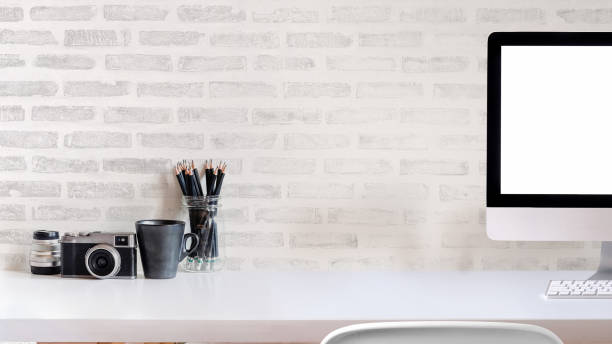 istock Office creative desk with supplies, and white brick wall. 990957832
