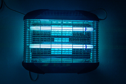 Blue insect zapper that is switched on and working away in Africa