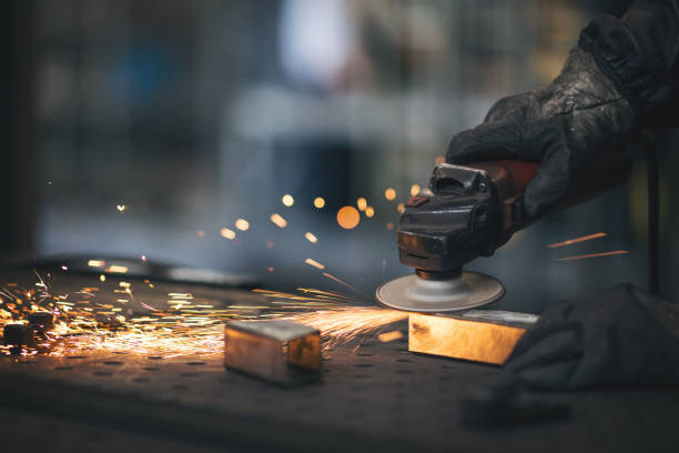 istock Young professional welder grinding and welding metal bars 990990766