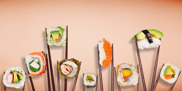 istock Traditional japanese sushi pieces placed between chopsticks on pastel color background 990991744
