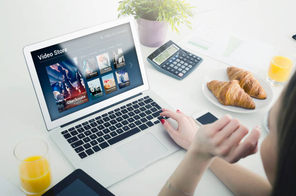 istock Woman using laptop for watching movie on VOD service. 990993210