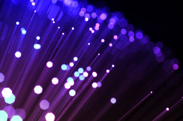 istock purple colored fiber optic abstract background on black. 991001472