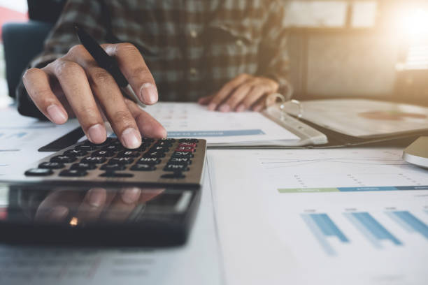 istock businessman working with calculator for financial document in office. male accountant doing accounting and calculating. bookkeeper making calculation. Savings, finance 991005096