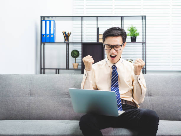 istock Young asian businessman smile successful sitting on sofa in office. 991017942