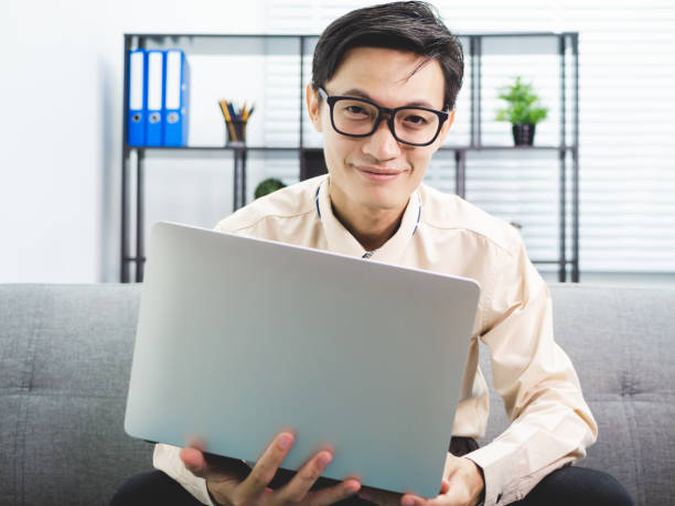 istock Young asian businessman smile successful sitting on sofa in office. 991018730