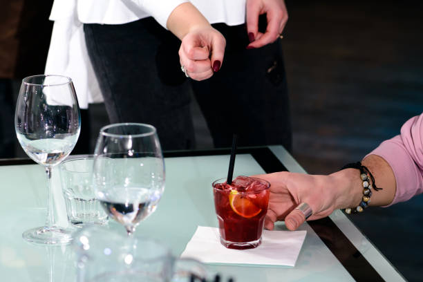 istock Unidentified man put the glass with cocktail at the table 991019048