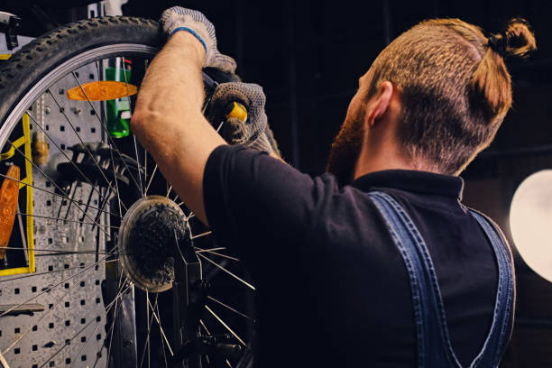 istock Mechanic repairing bicycle wheel tire in a workshop. 991019616