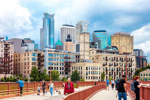 Minneapolis, Minnesota, USA - June 3, 2018: People walking on Stone Arch Bridge to cross Mississippi river.