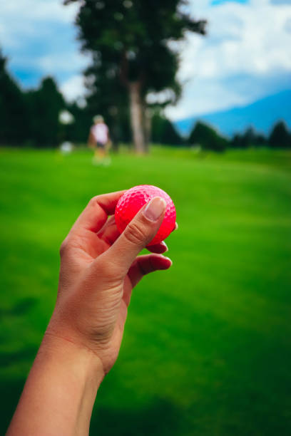 pelota de golf rosa mantenga en cielo de hierba, azul de la mujer mano verde curso. - golf women pink ball fotografías e imágenes de stock